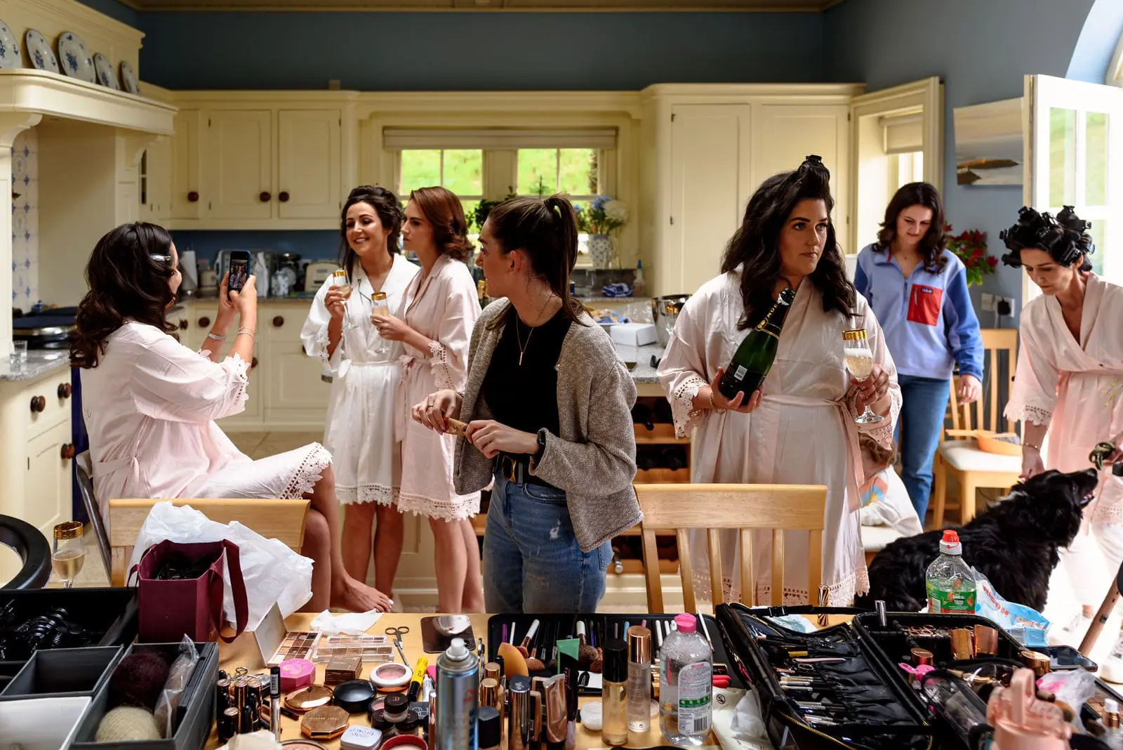 Montalto House,Zoe Flood & Keith Moloney, Busy kitchen on the morning of a wedding celebrations kicking off people drinking champagne makeup here being done